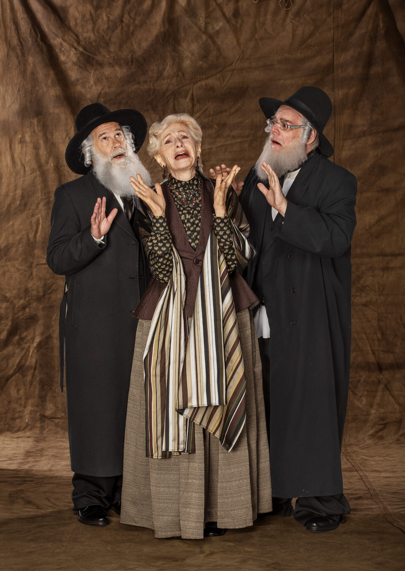 Três personagens de Dibuk, o Musical, em cena com figurinos tradicionais