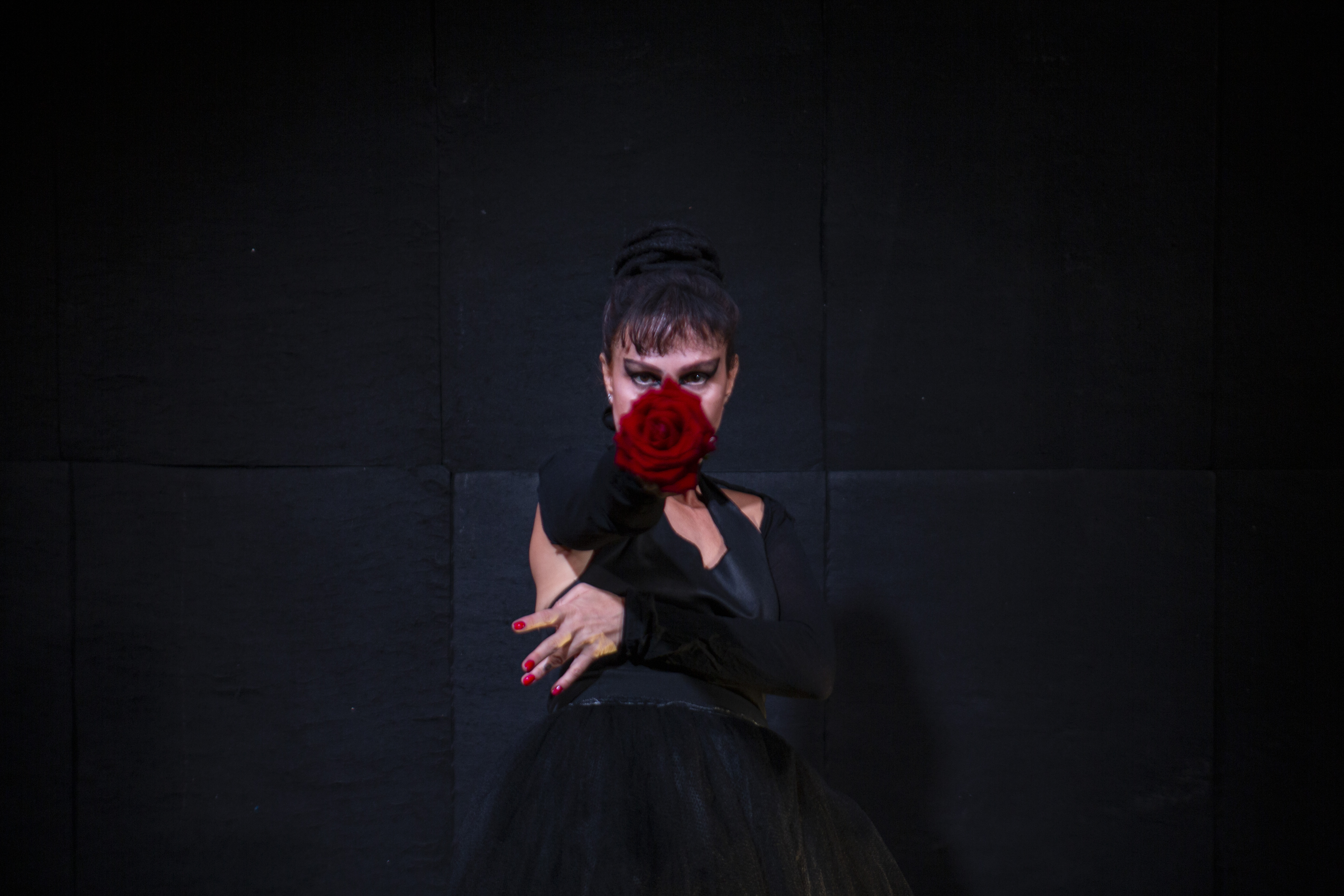 Luaa Gabanini em Baderna, oferecendo uma rosa vermelha em direção ao público