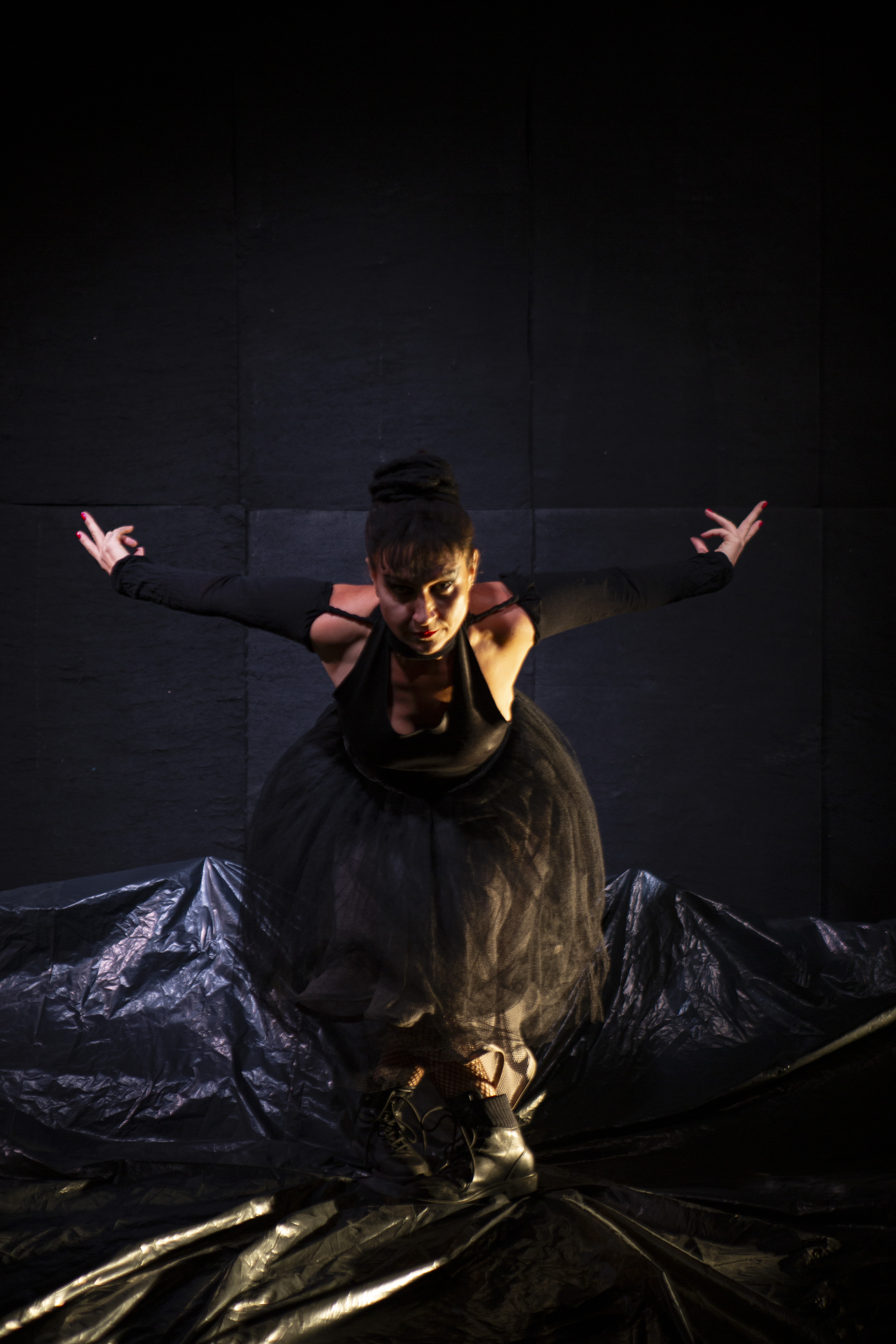 Luaa Gabanini em Baderna, sentada em cena com os braços abertos