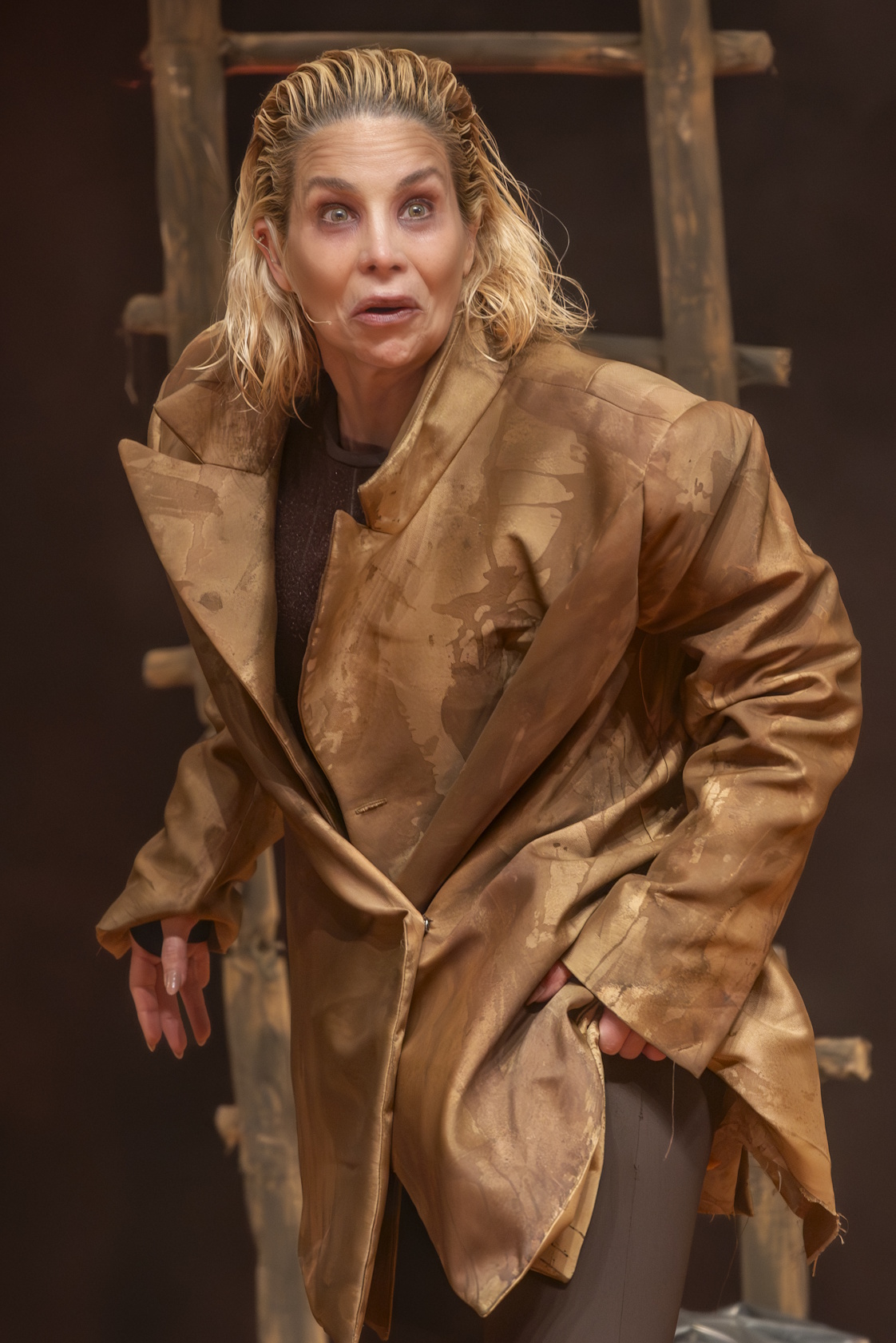 Close da atriz em cena, com escada ao fundo.